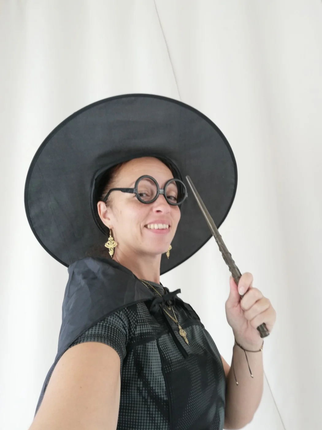Angélique porte un chapeau de sorcière et tient une baguette pour l’anniversaire yoga