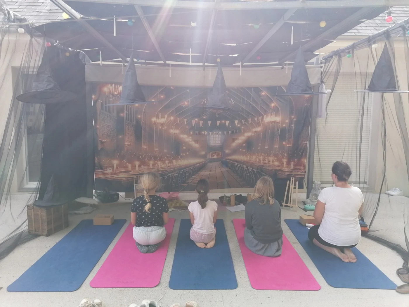 Les participants prennent une pause sur leurs tapis devant le décor de l’anniversaire magique